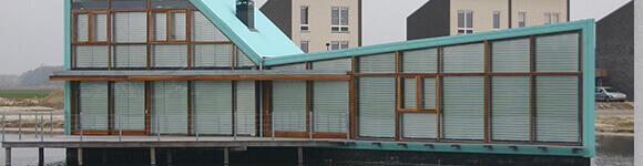 Haus mit unterschiedlichen Fensterflächen - rechteckig und dreieckig - mit Fläachenvorhängen von Multifilm